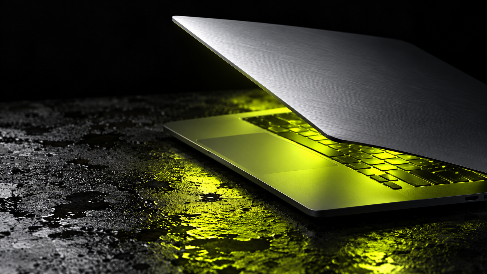 A silver laptop illuminated by chartreuse light
